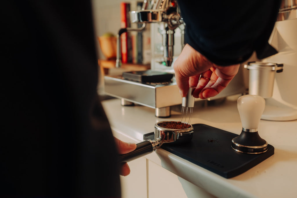 barista using wdt tool in portafilter