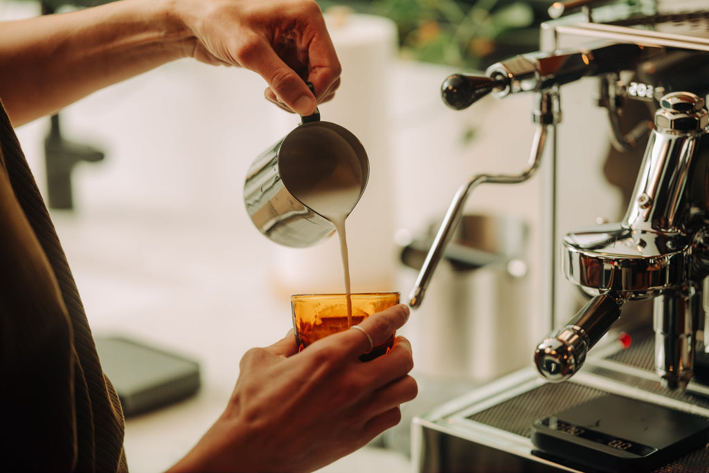 pouring latte art in a notNeutral vero amber cortado glass lifestyle by clive coffee