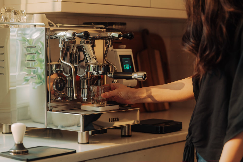 barista using the LUCCA M58 espresso machine side view lifestyle by Clive Coffee