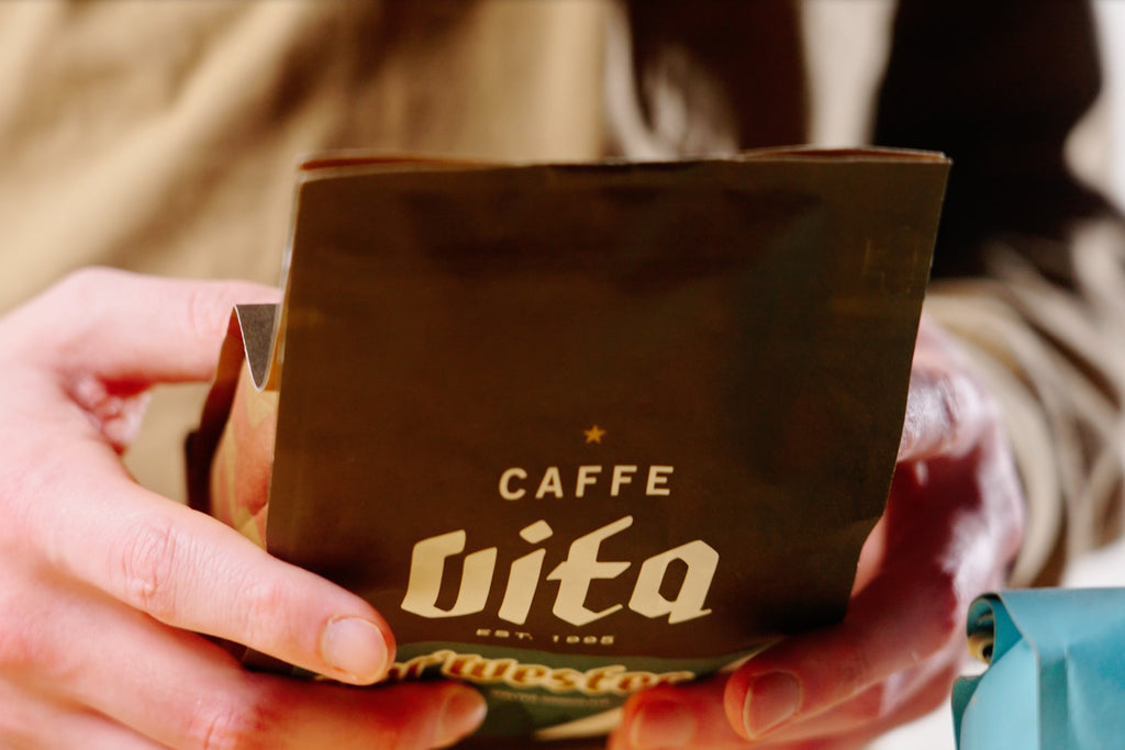 talent holding a bag of Cafe Vita coffee, looking for a roast date lifestyle by clive coffee