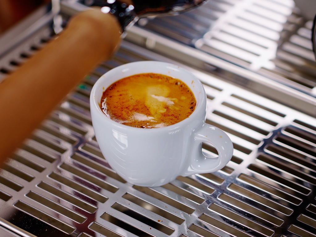 a shot of espresso in a mug on a drip tray lifestyle by clive coffee