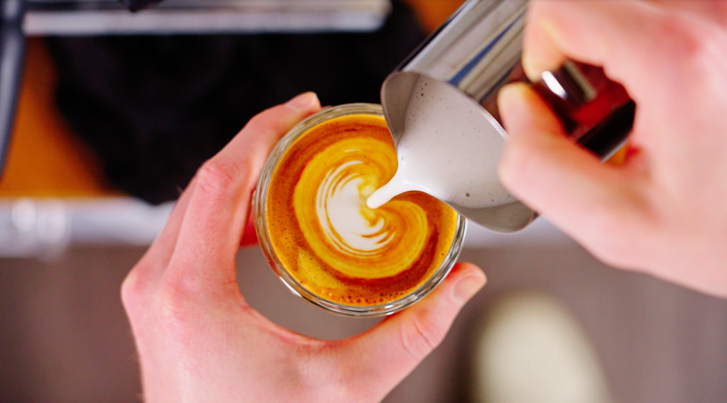 Pouring latte art overhead view lifestyle by clive coffee